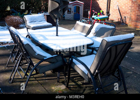 Outdoor patio table and chairs covered in snow, UK. Stock Photo