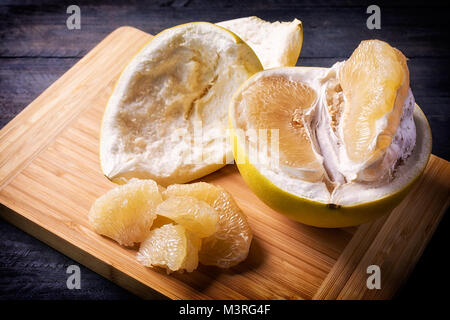 Closeup of sweet pomelo peeled on wooden background. Stock Photo