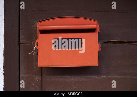Red mailbox with brown wood background. Stock Photo