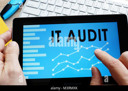 Man holding IT audit report in a tablet. Stock Photo