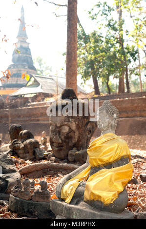 Ancient outdoor Buddhas field of broken sculpture in Wat Umong Suan Puthatham.The temple is a 700 year was built in 1297 in Chiang Mai city,Thailand. Stock Photo