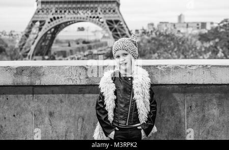 Bold Winter in Paris. Full length portrait of smiling trendy child in the front of Eiffel tower in Paris, France Stock Photo