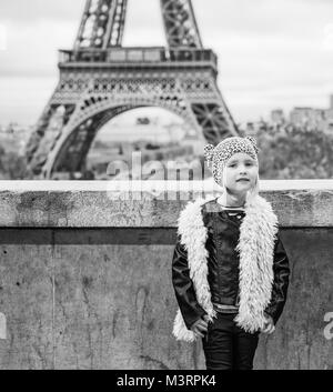 Bold Winter in Paris. Full length portrait of modern child standing against Eiffel tower in Paris, France Stock Photo