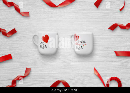 Loving couple cups with red decorations on white wooden table. Stock Photo