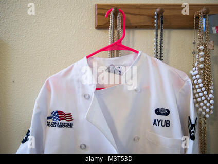 The chef's jacket of Airman 1st Class Alexandra Ayub, a missile chef for the 90th Force Support Squadron, hangs in her home at Francis E. Warren Air Force Base, Wyoming. Ayub deploys for four-day rotations to provide meals for the Airmen working at missile alert facilities, including the missileers in the launch control centers located beneath the MAF.  (U.S. Air Force photo/Staff Sgt. Andrew Lee) 160516-F-NL936-012 by AirmanMagazine Stock Photo