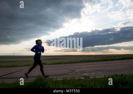 Airman 1st Class Alexandra Ayub, a missile chef, runs on a road near the missile alert facility (MAF) in Nebraska during a four-day deployment. Although Ayub works inside a fenced-in facility, she does her physical training outside of the gates in the vast expanse of open land that surrounds the MAF. (U.S. Air Force photo/Staff Sgt. Andrew Lee) 160515-F-NL936-132 by AirmanMagazine Stock Photo