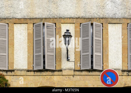 Traditional building facade with grey window shutters and a street lamp in Marciac, Gers (Gascony), Occitanie (Midi-Pyrénées), Southwest France Stock Photo