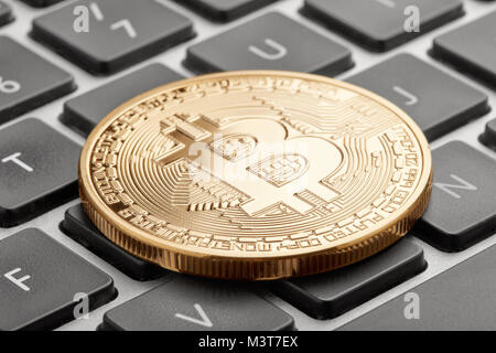 Golden bitcoin on computer keyboard with black keys Stock Photo