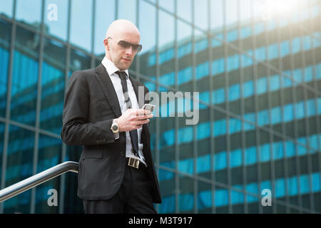 Portrait of smiling businessmen using mobile smart phone. Defocused Background Stock Photo
