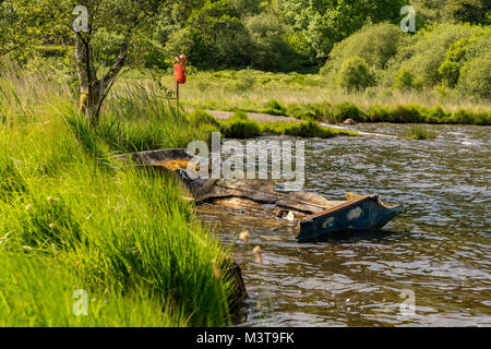 A damaged boat on the shore of Llyn Geirionydd, near Llanwrst, Conwy, Wales, UK Stock Photo