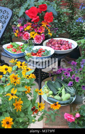 A bountiful harvest of fruit, flowers and vegetables from the garden displayed in bowls and pots Stock Photo