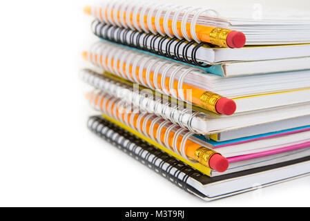 Stack of colorful notebooks with pencils isolated on white Stock Photo