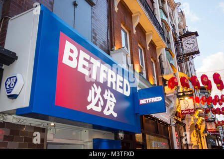 Betfred betting shop surrounded by Chinese New Year red paper lanterns in Soho, Chinatown, London, W1, UK Stock Photo