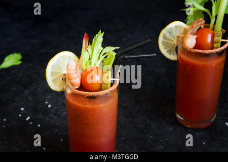 Bloody Mary Cocktail in glasses with garnishes. Tomato Bloody Mary spicy  drink on black stone background with copy space Stock Photo - Alamy