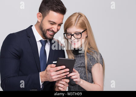 Happy young businessman and businesswoman using tablet, studio shoot Stock Photo