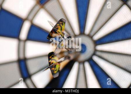 three darts at dart game just hit the bullseye in Stock Photo