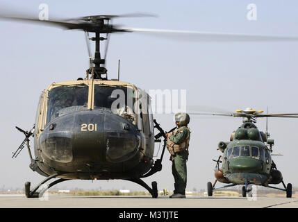 An Iraqi UH-1H and an Iraqi Mi-17 Hip helicopter prepare to transport a wounded Iraqi service member from Joint Base Balad, Iraq, to Forward Operating Base Gabe in Baqubah.  (U.S. Air Force photo by Airman 1st Class Jason Epley) CurrentHuey004 by AirmanMagazine Stock Photo