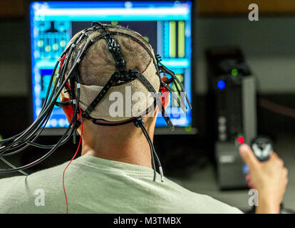 A test subject uses the Multi-Attribute Task Battery to perform a multitasking cognitive test while electrodes administer directed electrical brain stimulation in the Non-Invasive Brain Stimulation (NIBS) lab at the Air Force Research Laboratory, Wright Patterson Air Force Base, Ohio, Jul 19, 2016. Researchers working in the NIBS lab, led by Dr. Richard A. McKinley, Ph.D., are exploring how directed electrical stimulation to the human brain affects cognition, fatigue, mood and other areas with the end goal of improving warfighter awareness, memory and focus. (U.S. Air Force photo by J.M. Eddin