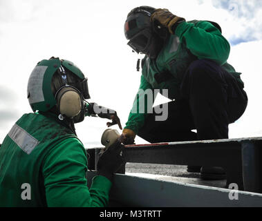 PACIFIC OCEAN (Oct. 16, 2016)- Petty Officer 3rd Class Mutarr Fatty (Left) talks to Petty Officer 3rd Class Michael Toone during flight operations on the flight deck of USS Nimitz (CVN 68). Nimitz is underway to complete flight deck certification and carrier qualifications for an upcoming 2017 deployment. (U.S. Navy photo by Petty Officer 2nd Class Holly L. Herline/Released) 161016-N-KR702-127 by USS NIMITZ (CVN 68) Stock Photo