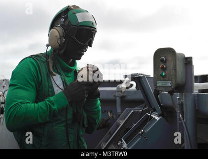 PACIFIC OCEAN (Oct. 16, 2016)- Petty Officer 3rd Class Mutarr Fatty (Left) serves as the arresting gear deck edge operator during flight operations on the flight deck of USS Nimitz (CVN 68). Nimitz is underway to complete flight deck certification and carrier qualifications for an upcoming 2017 deployment. (U.S. Navy photo by Petty Officer 2nd Class Holly L. Herline/Released) 161016-N-KR702-163 by USS NIMITZ (CVN 68) Stock Photo