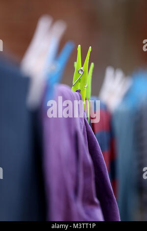 Clothes pegs holding washing on a clothes line, in Peterborough, Cambridgeshire, on February 12, 2018. Stock Photo