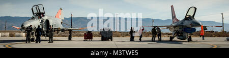 Ground crew of 82nd Aerial Target Squadron Detachment 1 perform maintenance on a QF-4 Phantom, left,  and its replacement, the QF-16, at Holloman AFB, N.M., Dec. 20, 2016. The final variant of the Phantom II, the primary multi-role aircraft in the USAF throughout the 1960s and 1970s, was the QF-4 unmanned aerial target flown by the 82nd at Holloman AFB. Pilots of the 82nd flew the F-4 for the last time prior to a retirement ceremony for the storied aircraft on Dec. 21, 2016. (U.S. Air Force photo by J.M. Eddins Jr.) 001 161220-F-LW859-001 Stock Photo