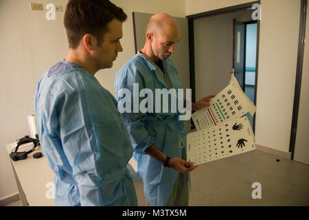 U.S. Army Capt. Nate Jordan, an resident, and U.S. Air Force Maj. Brett Davies, an ocular trauma and plastic surgeon, review the eye charts before examining post operation patients at the Centro Hospitalario Luis 'Chicho' Fabrega during a medical readiness training exercise in Santiago, Panama, Feb. 7, 2017. The U.S. military medical team was in Panama to help treat individuals with cataracts that otherwise would have gone untreated. Medical readiness training exercises provide U.S. military personnel training in delivery of medical care in austere conditions, promote diplomatic relations betw Stock Photo