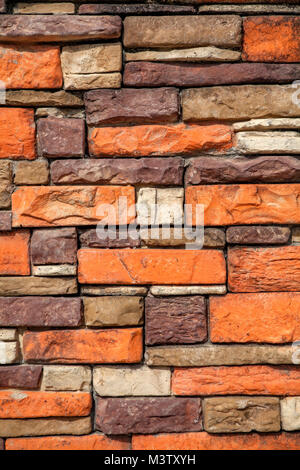 Orange, manufactured, artificial bricks stacked as a landscaping wall. Stock Photo