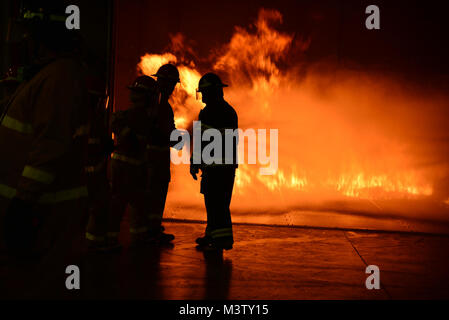 170222-N-BN978-001 GREAT LAKES, Ill. (Feb. 22, 2017) A group of students fight a fire at the new Fire Fighting Trainer at Surface Warfare Officers School Unit Great Lakes. Over 50 students took part in the two day training that will train more than 10,800 students and staff members take part in the training annually. (U.S. Navy photo by Brian Walsh/Released) 170222-N-BN978-001 by Photograph Curator Stock Photo