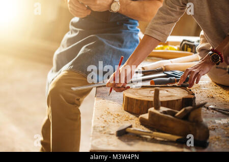 Carpenter Training Female Apprentice To Use Plane Stock Photo