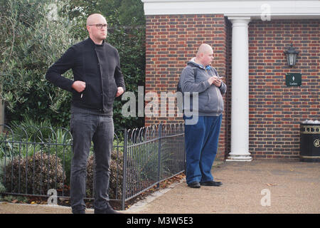 Two men waiting outside a female public toilet in Hyde Park, London for their partners to come out Stock Photo