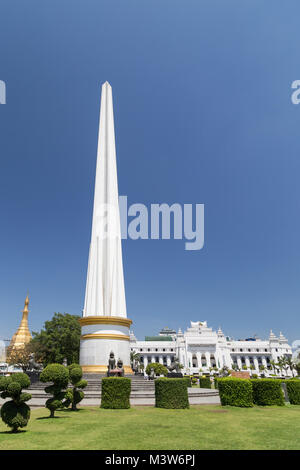 Independence Monument at the Maha Bandula Park on a sunny day in downtown Yangon, Myanmar. Sule Pagoda and the Yangon City Hall are in the background. Stock Photo