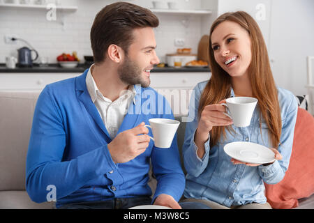 Young couple together at home weekend drinking coffee talking Stock Photo