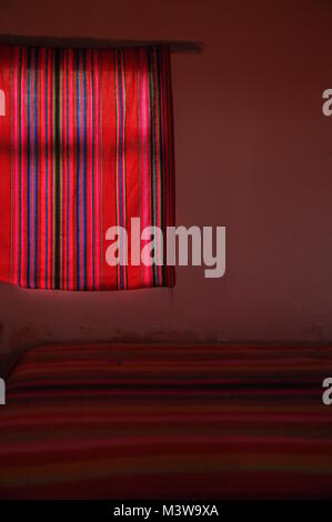 Interior shot of a bedroom decorated with colorful indigenous textiles in Lake Tititcaca, Peru Stock Photo