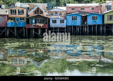 Colorful wooden houses on stilts reflected in water on the island of Chiloe, Chile Stock Photo