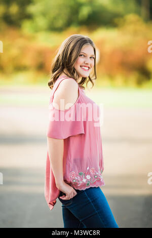 High school senior girl portraits outside during summertime. One person. Beautiful brunette teenage female. Stock Photo