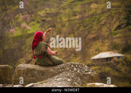 A woman Spinning yarn in a Himalayan village Stock Photo