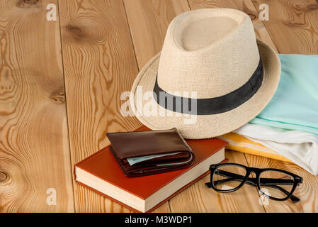 set of clothes and accessories prepared for travel close-up on a wooden background Stock Photo