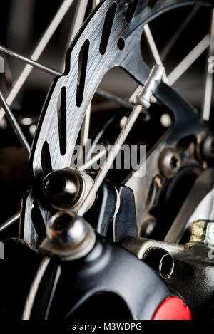 steel shiny bicycle brake disc close-up on a dark background Stock Photo