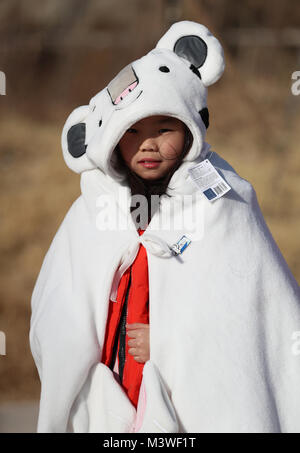 A young girl dresses as the Olympic Games mascot in the Olympic Park during day four of the PyeongChang 2018 Winter Olympic Games in South Korea. Stock Photo