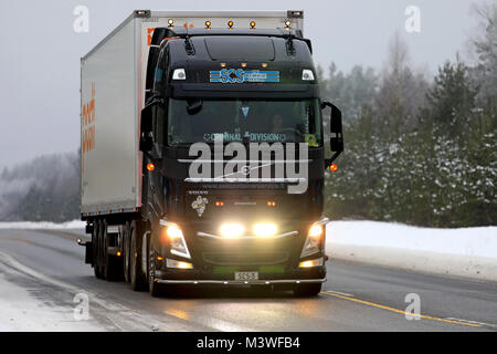 RAASEPORI, FINLAND - FEBRUARY 9, 2018: Beautifully customized black Volvo FH truck of SCS for Posti Group transports lights up the wintery highway in  Stock Photo