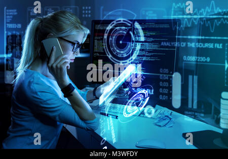 Serious clever programmer talking on the phone and looking strict Stock Photo