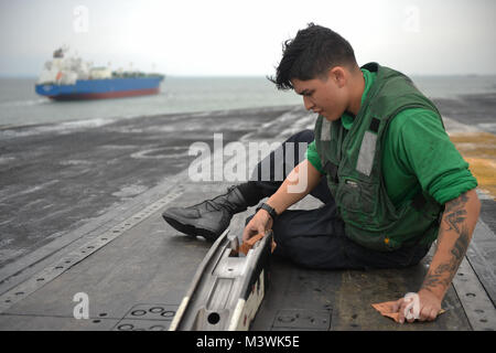 SINGAPORE STRAIT (July 6, 2017) U.S. Navy Aviation Boatswain's Mate (Equipment) Airman Miguel Torres Sandoval, a native of Long Beach, Calif., cleans a catapult system aboard the aircraft carrier USS Nimitz (CVN 68), July 6, 2017, in the Singapore Strait. Nimitz is currently on deployment in the U.S. 7th Fleet area of operations. The U.S. Navy has patrolled the Indo-Asia Pacific routinely for more than 70 years promoting regional peace and security. (U.S. Navy photo by Mass Communication Specialist 3rd Class Cole Schroeder) 170706-N-JH929-080 by Naval Base Kitsap (NBK) Stock Photo