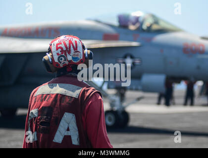 ARABIAN GULF (July 31, 2017) U.S. Navy Aviation Ordnanceman 2nd Class Zachary Watts, from Cedar Springs, Mich., observes flight operations aboard the aircraft carrier USS Nimitz (CVN 68), July 31, 2017, in the Arabian Gulf. Nimitz is deployed in the U.S. 5th Fleet area of operations in support of Operation Inherent Resolve. While in this region, the ship and strike group are conducting maritime security operations to reassure allies and partners, preserve freedom of navigation, and maintain the free flow of commerce. (U.S. Navy photo by Mass Communication Specialist 3rd Class Ian Kinkead) 1707 Stock Photo