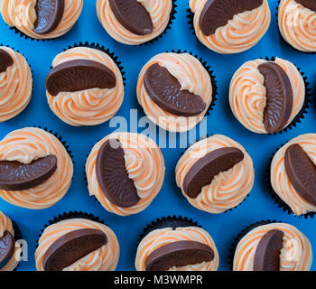 Colourful chocolate orange cupcakes on a blue background. Pattern Stock Photo