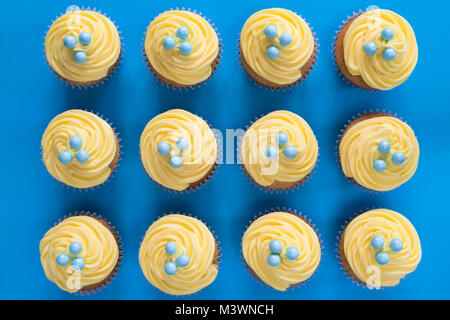 Colourful yellow lemon cupcakes on a blue background. Pattern Stock Photo