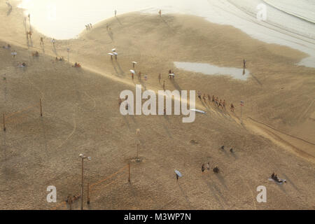 People begin to leave a winter Tel Aviv beach at sunset. Stock Photo