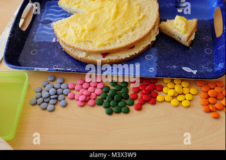 Cake on tray whit coloured sweets in front Stock Photo
