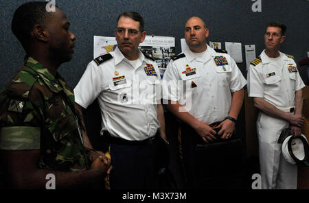 Col. Dallas WIngate, Sgt. Donald Powell and Capt. Phil Fowler receive an overview on the Operation of Disaster Preparedness and Management's radio room, an extension of their Emergency Operations Center, from a member of the Trinidad and Tobago Defence Force. (U.S. Army National Guard photo by Staff Sgt. Wendy McDougall) 140409-Z-ZB970-108 by ussouthcom Stock Photo