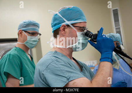 U.S. Air Force Maj. (Dr.) Forrest Jellison, urologist, right, peers through a scope while Capt. (Dr.) Matthew Stringer, urology resident, observes during a urology procedure scheduled as part of a New Horizons Belize 2014 medical readiness training exercise May 22, 2014, at the Karl Heusner Memorial Hospital in Belize City, Belize. A U.S. Air Force surgical team arrived in Belize to spend two weeks conducting urology procedures and surgeries in coordination with the KHMH urologist. Approximately 40 patients were screened through the KHMH, and about 20 procedures are planned during this phase o Stock Photo